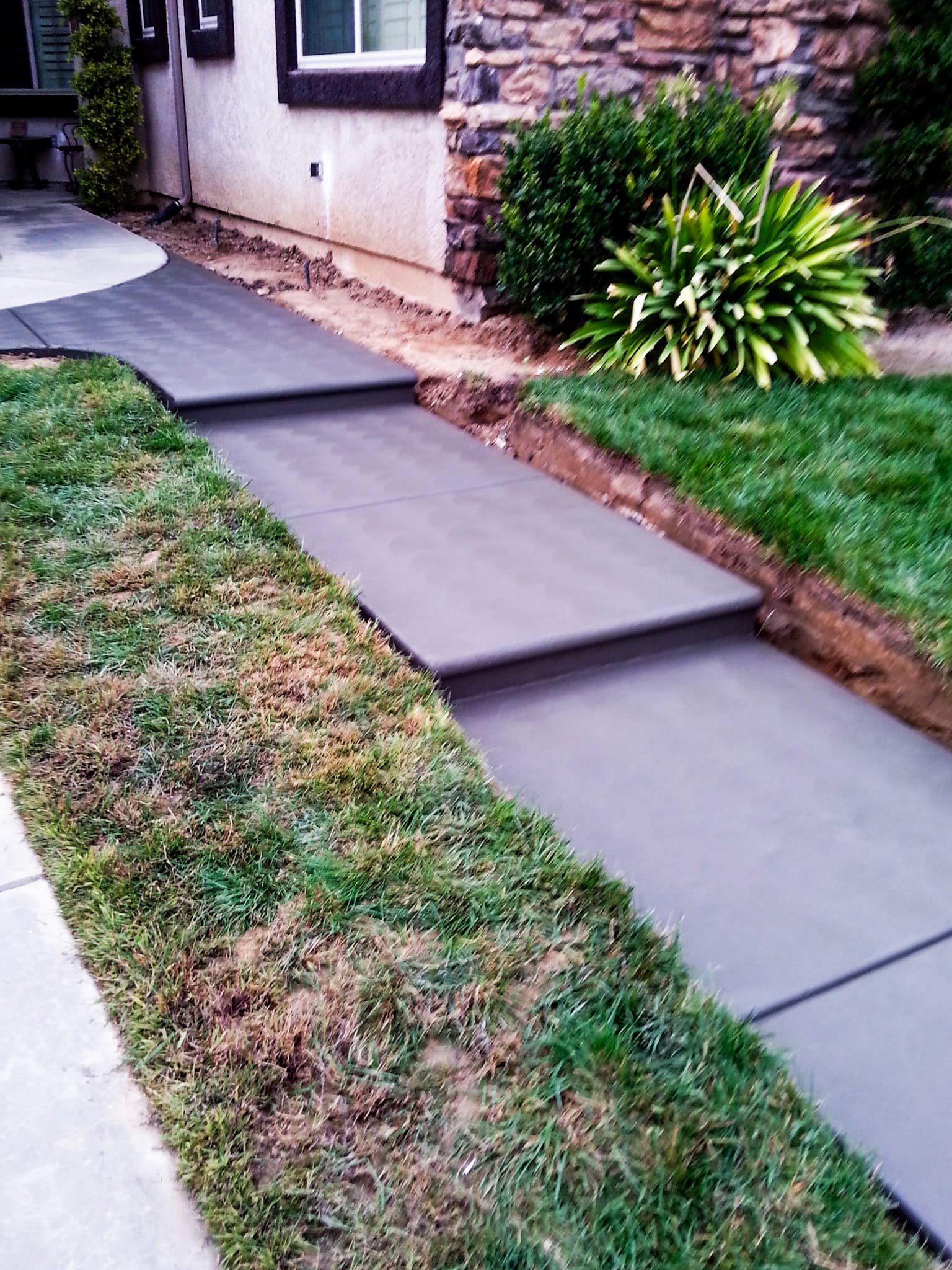 Concrete entryway to a home's front door